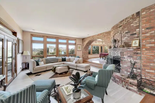 a living room with furniture and a floor to ceiling window