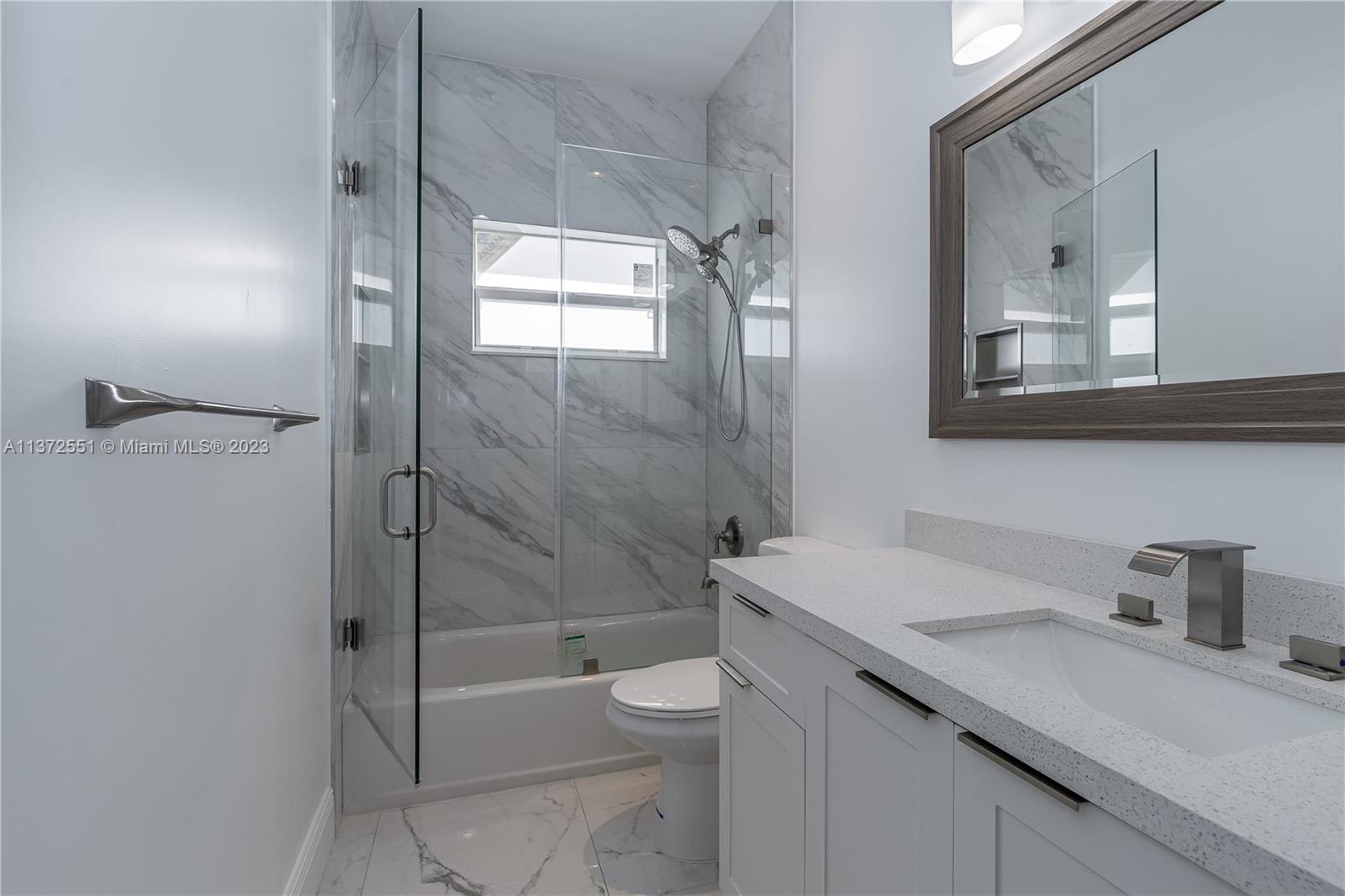 6109 Edwards Road Margate, FL 33063 - Photo 24 of 31 a bathroom with a granite countertop sink a toilet and shower