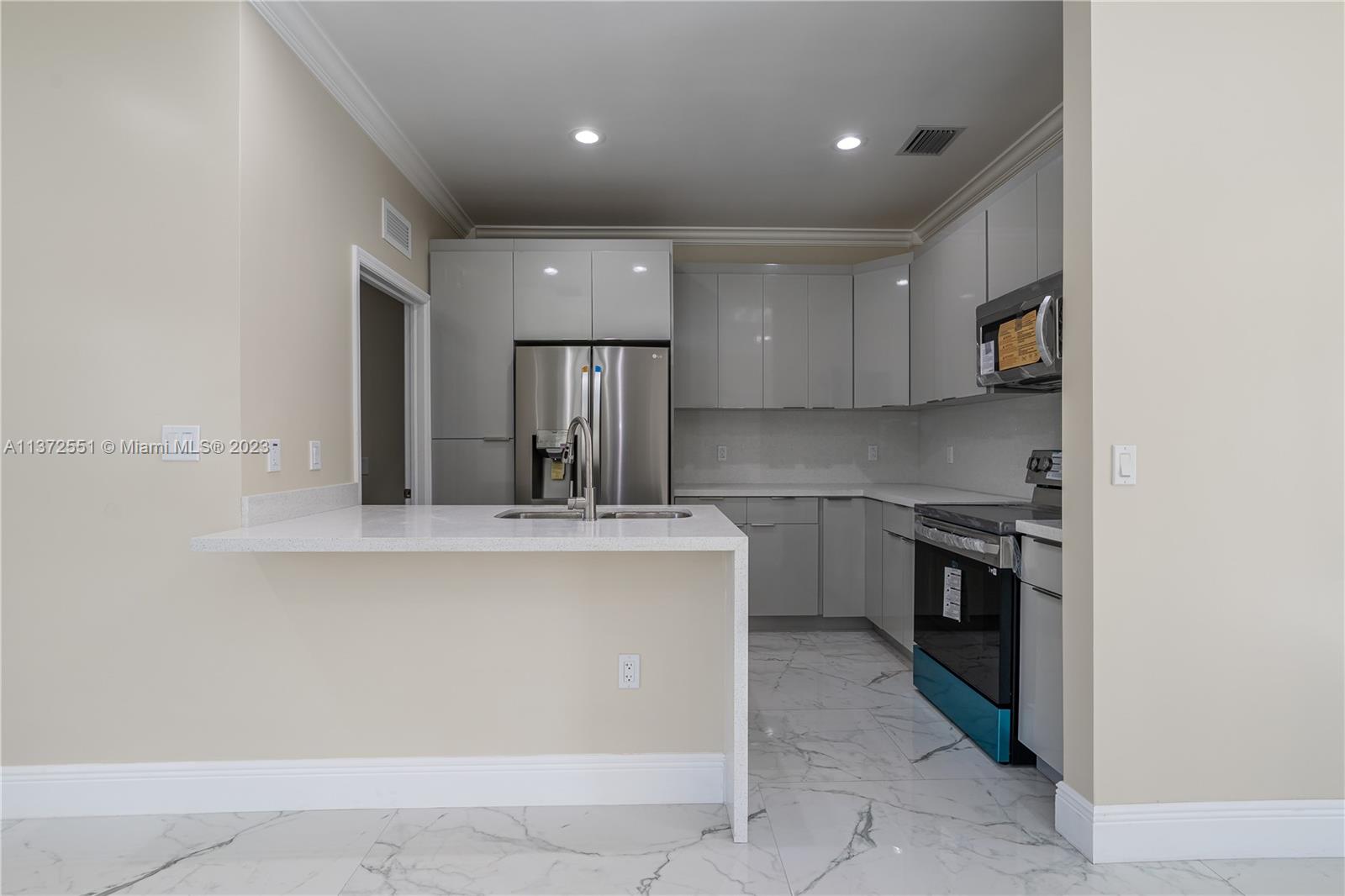 6109 Edwards Road Margate, FL 33063 - Photo 29 of 31 a kitchen with stainless steel appliances granite countertop a stove a sink and a refrigerator