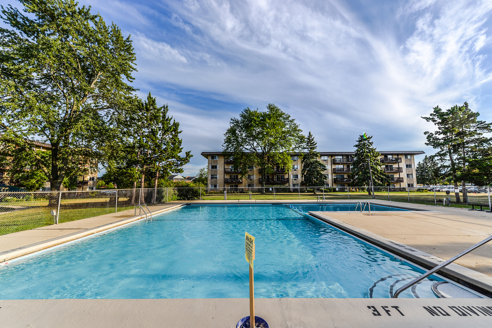 2226 South Goebbert Road, Unit 270 Arlington Heights, IL 60005 - Photo 24 of 27 a view of swimming pool with seating space and trees in the background
