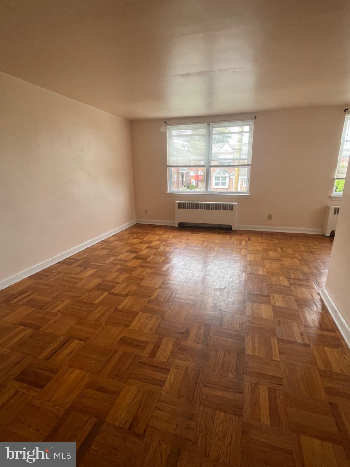 Spacious room with warm wooden floors.