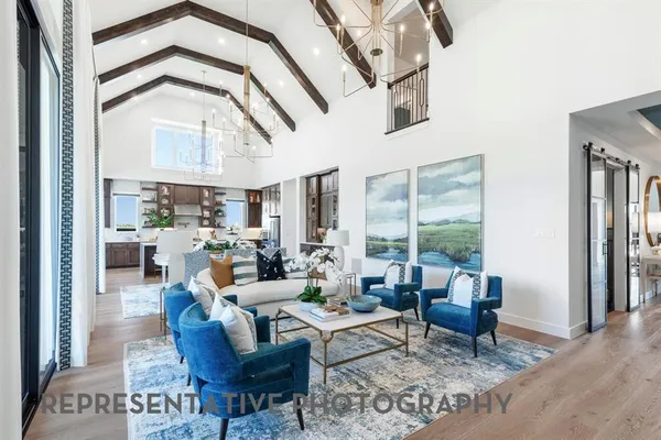 a living room with furniture large window and wooden floor