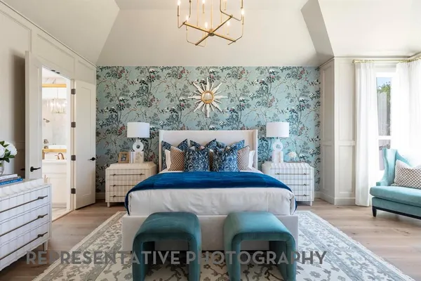 a bed sitting in a bedroom next to a window with a table and chair