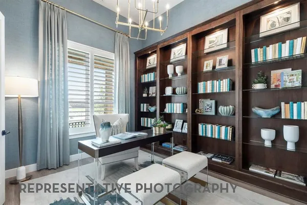 a living room with furniture a bookshelf and a window