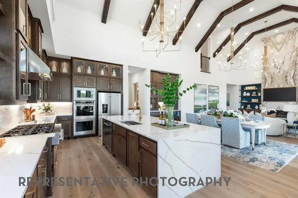 a large white kitchen with a large window and counter top space
