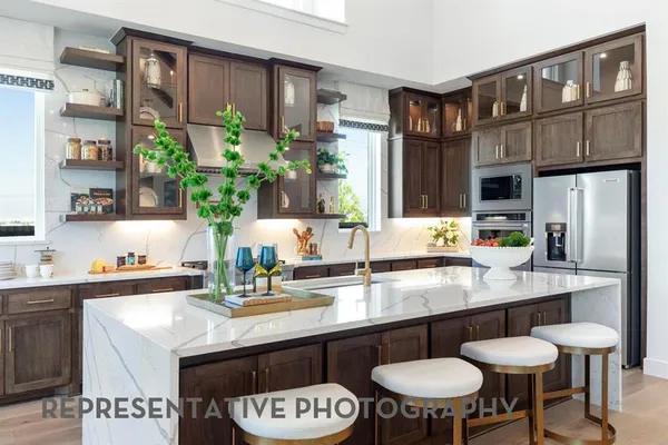 a kitchen with stainless steel appliances granite countertop a table chairs sink and cabinets