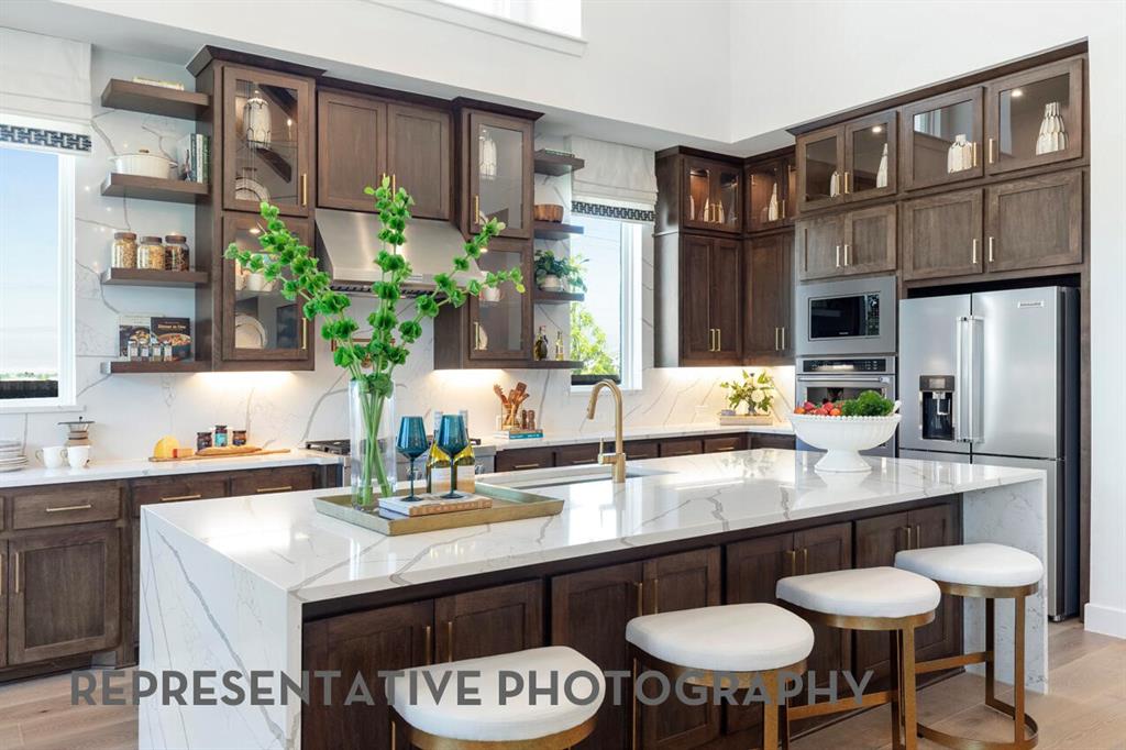 3908 Meander Way Prosper, TX 75078 - Photo 9 of 37 a kitchen with stainless steel appliances granite countertop a table chairs sink and cabinets