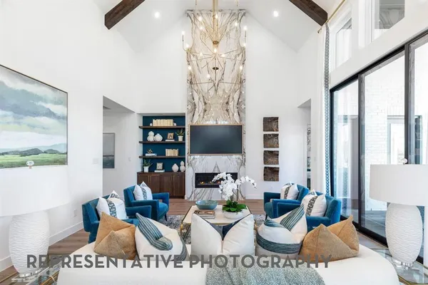a living room with furniture a chandelier and a painting