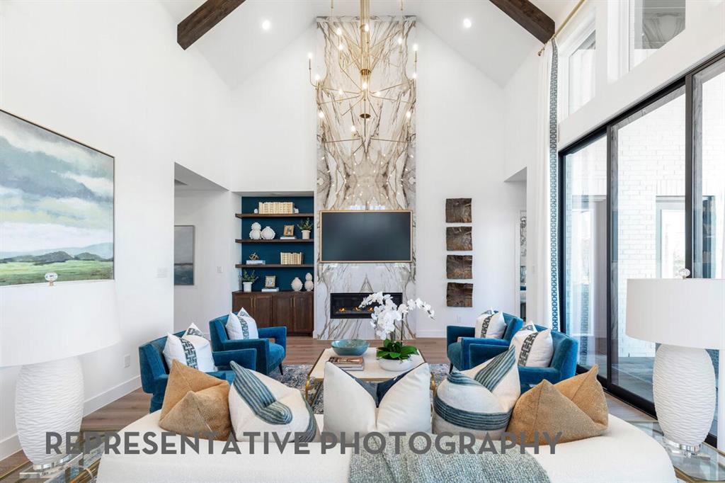 3908 Meander Way Prosper, TX 75078 - Photo 10 of 37 a living room with furniture a chandelier and a painting