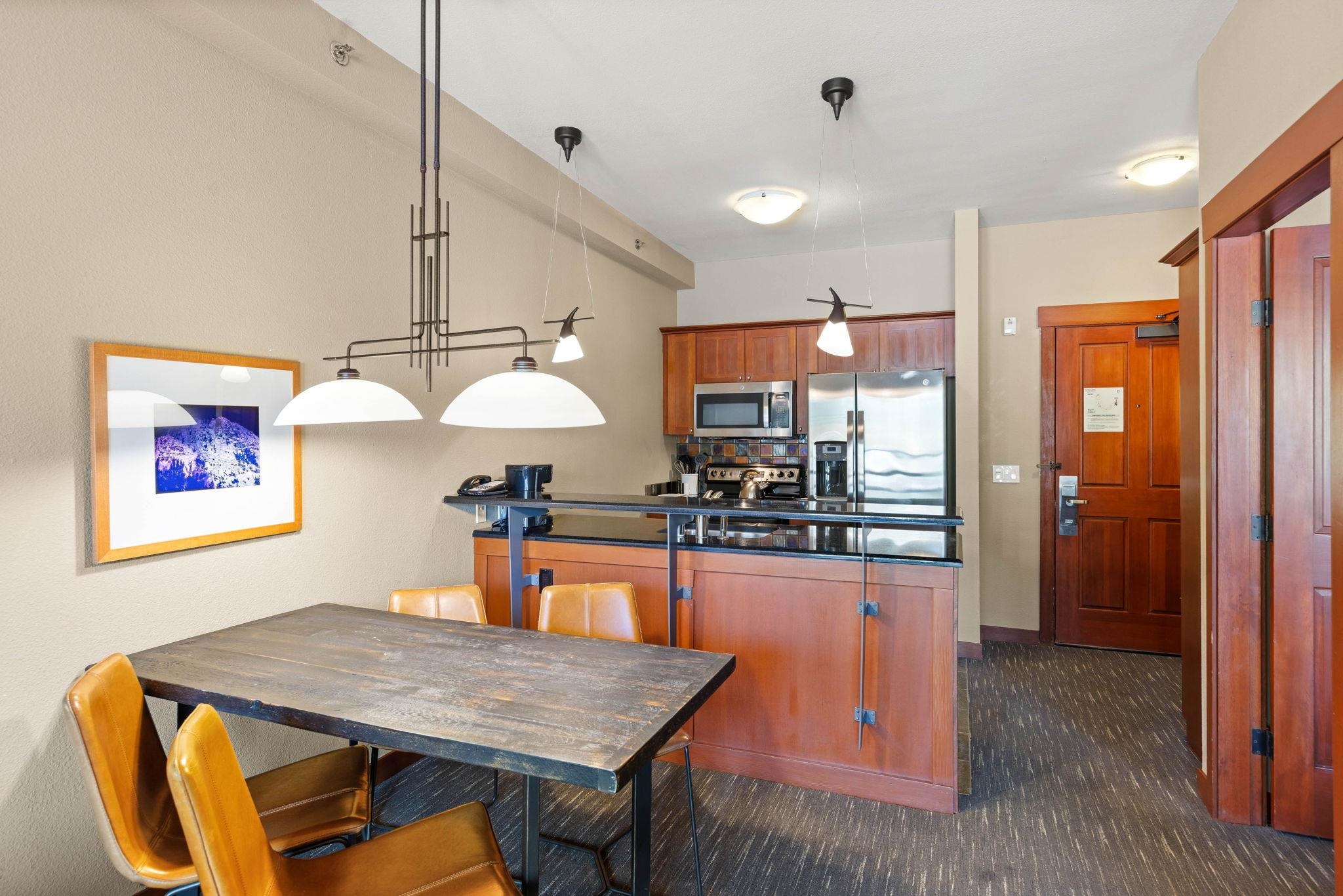 1850 Village South Road, Unit 4327 Olympic Valley, CA 96146 - Photo 10 of 25 a kitchen with stainless steel appliances wooden floor dining table and chairs