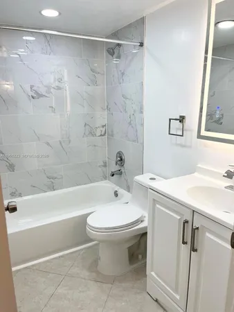 a white toilet sitting next to a shower