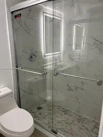 a bathroom with a toilet and a shower