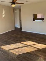 a view of room with wooden floor and fan