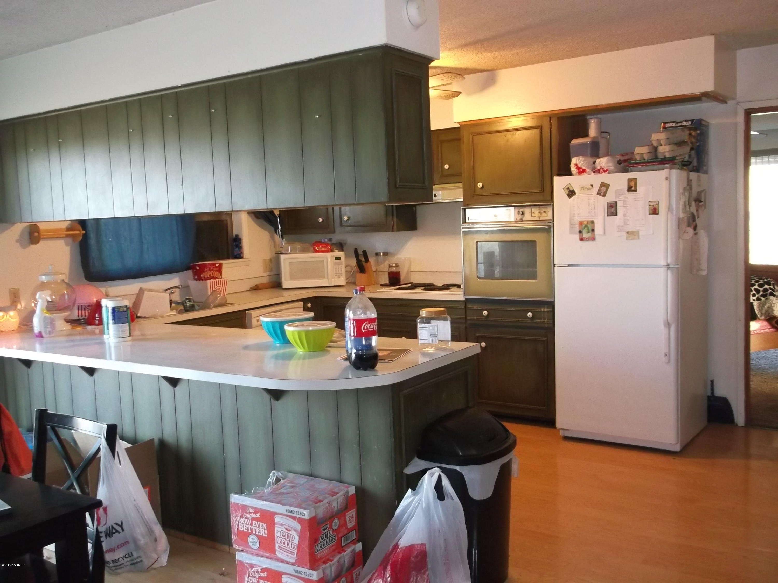 420 Albro Road Sunnyside, WA 98944 - Photo 3 of 8 a kitchen with a refrigerator and a stove top oven