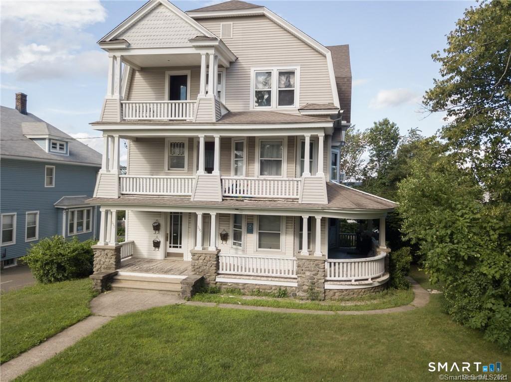 393 Highland Avenue, Unit 2 Waterbury, CT 06708 - Photo 1 of 10 a front view of a house with a yard