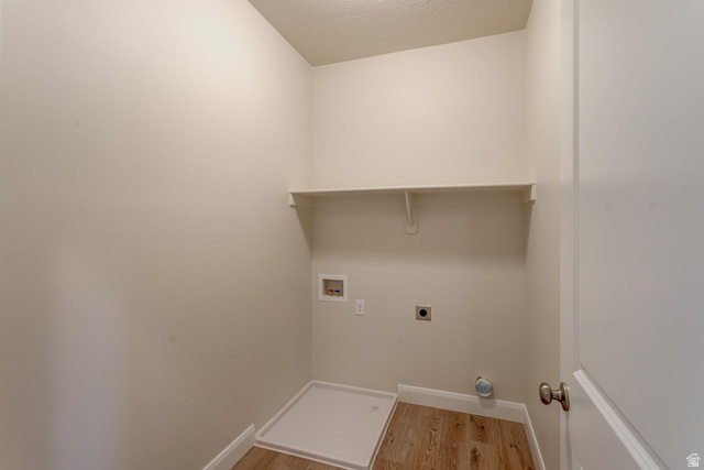1512 West 600 North, Unit O4A Mapleton, UT 84664 - Photo 9 of 24 Laundry room featuring light wood-type flooring, washer hookup, a textured ceiling, and hookup for an electric dryer