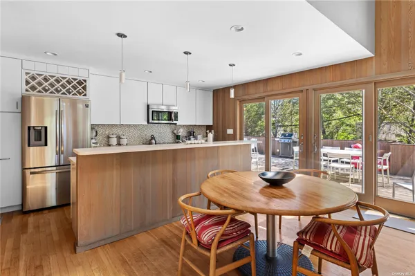 a kitchen with stainless steel appliances granite countertop a stove a refrigerator a kitchen island a table and chairs