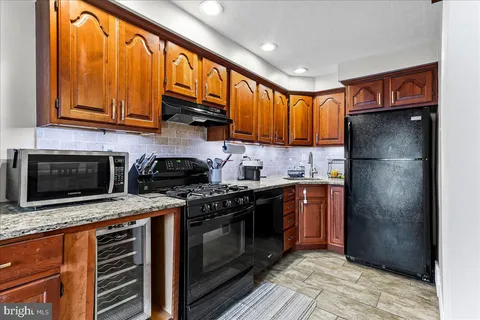 a kitchen with stainless steel appliances granite countertop a stove a refrigerator and a sink