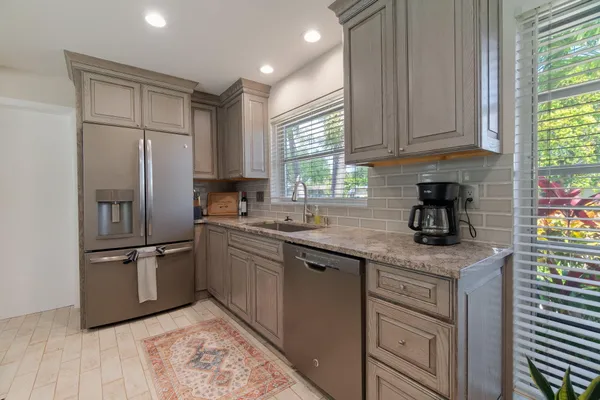 a kitchen with stainless steel appliances granite countertop a refrigerator sink and stove