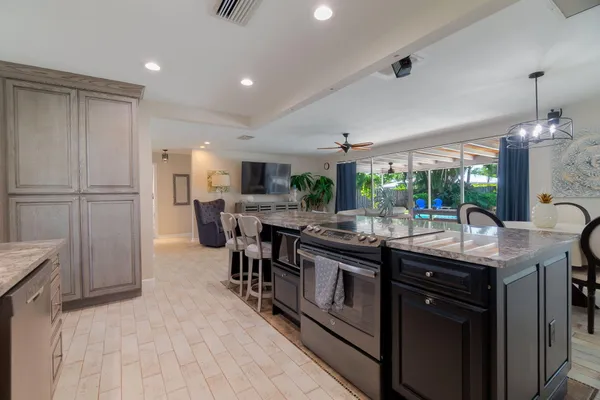 a kitchen with kitchen island granite countertop lots of counter top space and stainless steel appliances