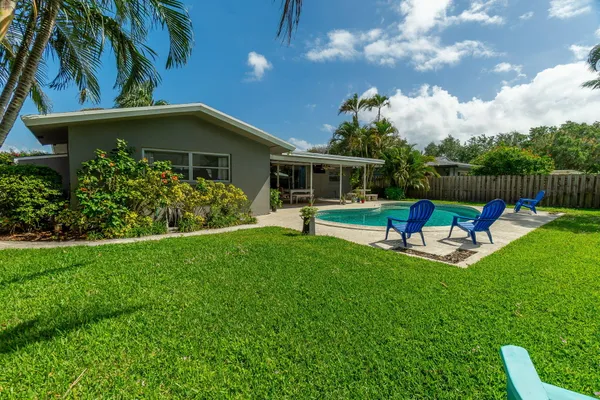 a view of a chair and table in backyard of the house