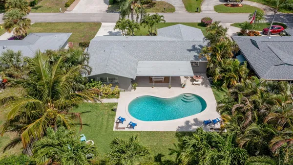 an aerial view of a house with a swimming pool and garden