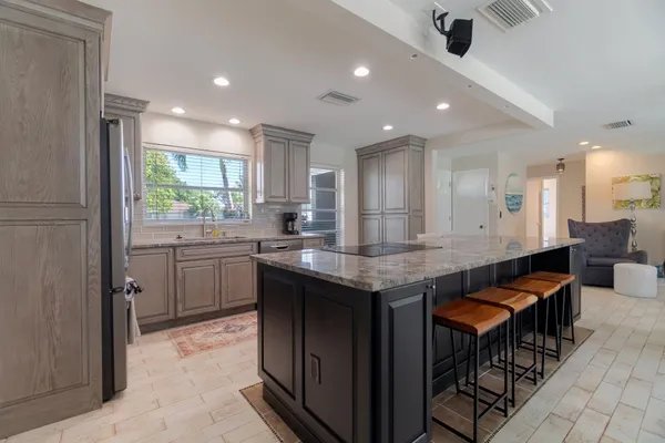 a kitchen with granite countertop kitchen island stainless steel appliances a sink and counter space