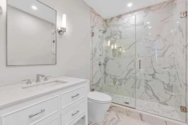 a bathroom with a sink a toilet and shower