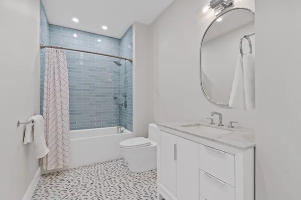 a bathroom with a granite countertop sink a toilet and shower