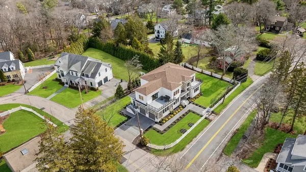 an aerial view of a house with a garden and lake view