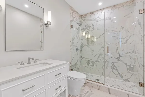 a bathroom with a sink a toilet and shower