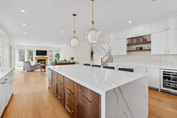 a large kitchen with stainless steel appliances a large center island attached withe living room