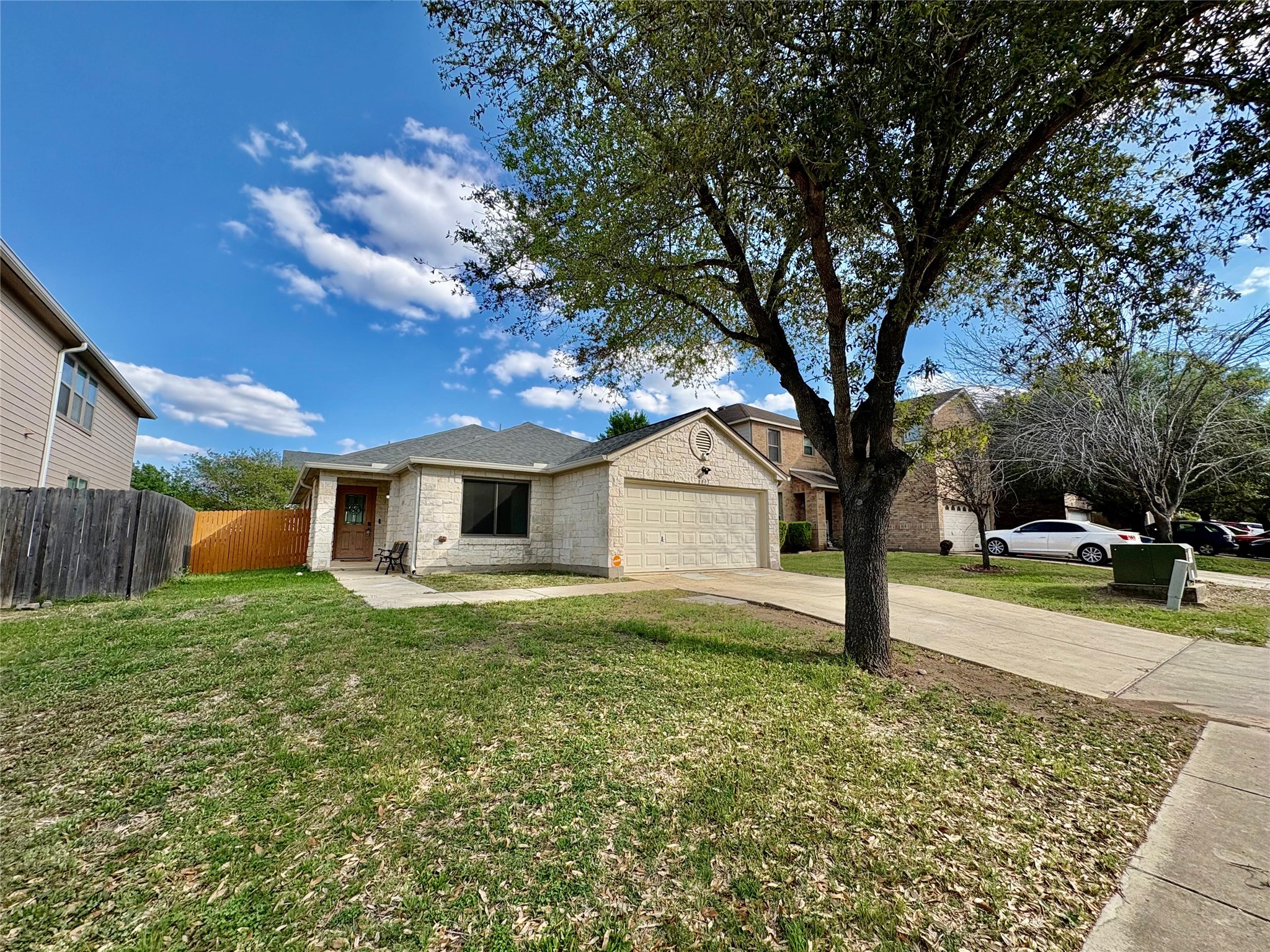8003 Bannock Lane Austin, TX 78747 - Photo 2 of 40 Ranch-style home with an attached garage, driveway, and brick siding
