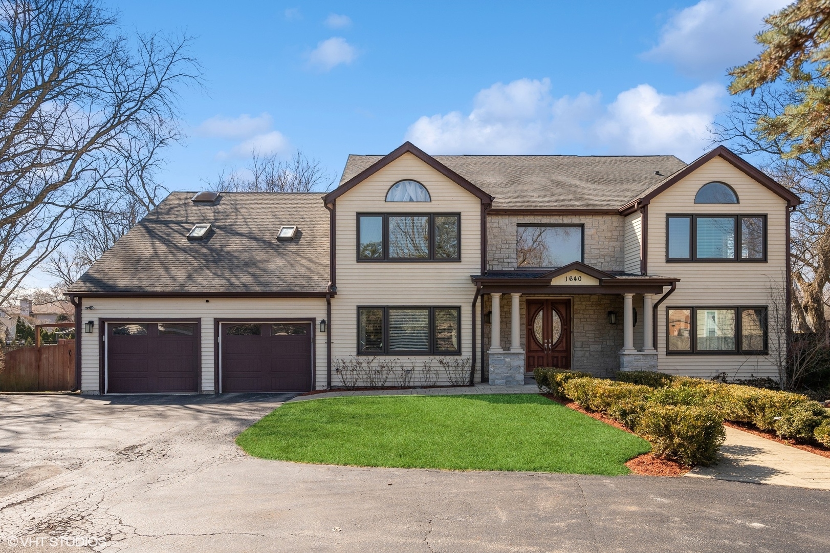a front view of a house with a garden and yard