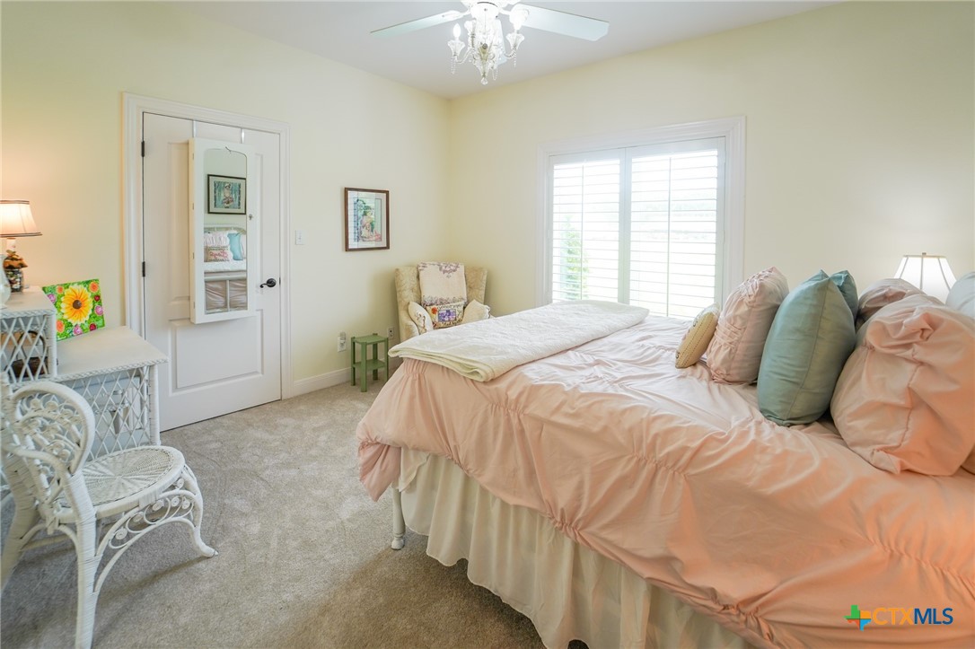 501 Barbara Street Ganado, TX 77962 - Photo 17 of 43 a bedroom with a bed and a chandelier