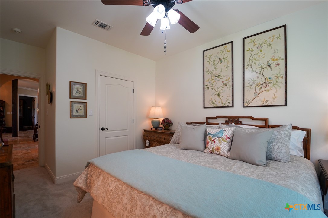 501 Barbara Street Ganado, TX 77962 - Photo 43 of 43 Another secondary bedroom is shown here. There is a walk-in closet with rods & shelves, 2 windows with wood blinds, new carpet in summer, 2025 and is ample in size to accommodate a king size bed, night stands and chest. As it is presently furnished, it serves as a comfy guest room and is adjoins the other side of the Jack & Jill bath. Both secondary bedrooms represent a split floorplan from the primary bedroom's location, making these areas pleasing for guests or additional family members of all ages.