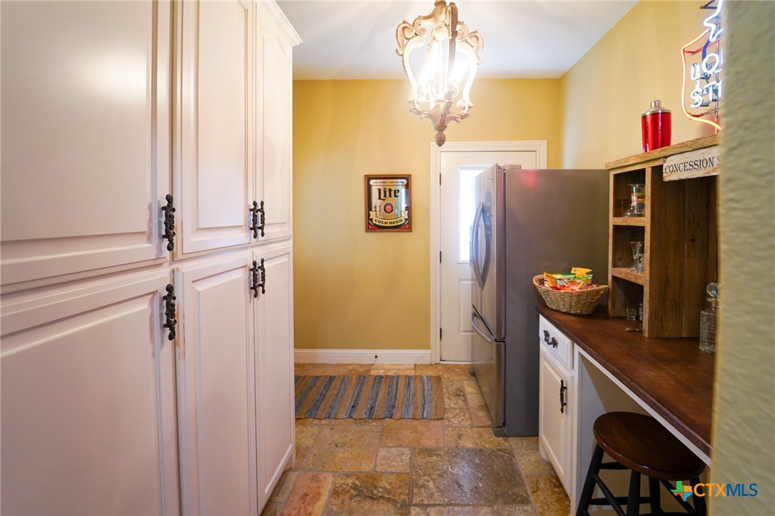 501 Barbara Street Ganado, TX 77962 - Photo 22 of 43 Just beyond the laundry area is this space with lots of floor-to-ceiling, deep cabinets. There's no more wondering where to put all the warehouse club bulk items or pantry over-flow. There is also a built-in counter top with knee space, flanked by cabinets and drawers and an optional 2nd refrigerator space.