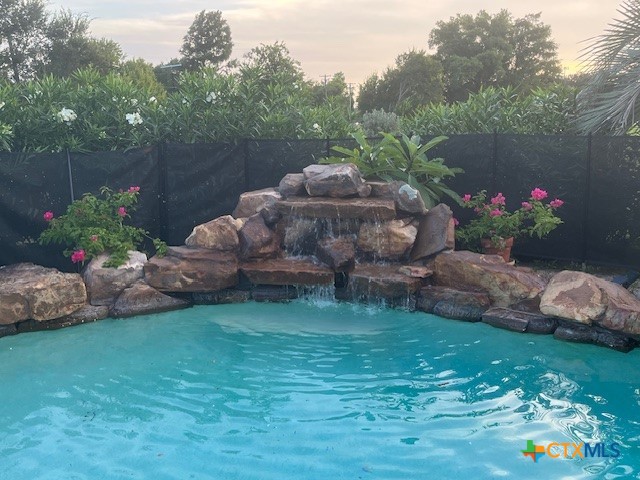 501 Barbara Street Ganado, TX 77962 - Photo 28 of 43 The gently trickle of the water fall with lush vegetation as a backdrop is a refreshing respite whether you're in the water or just admiring it from the covered pergola or sunning on a lounge chair on the deck.