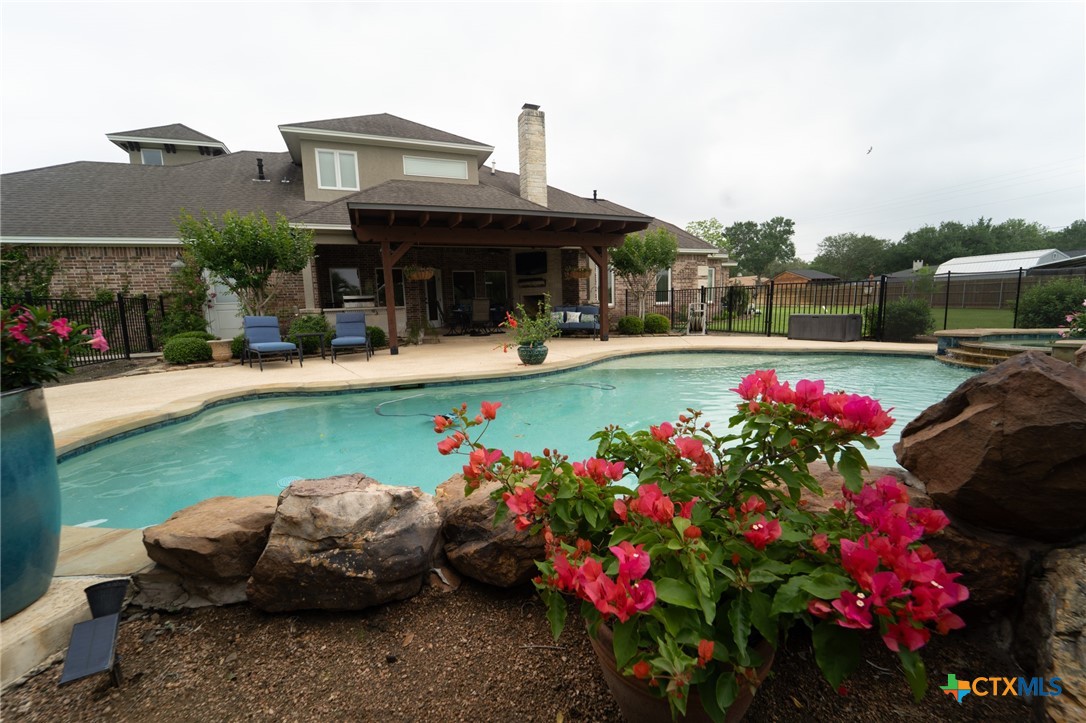 501 Barbara Street Ganado, TX 77962 - Photo 29 of 43 This backyard oasis with pool, hot tub and plentiful, colorful plantings is visually appealing and is the source for lots of fun, relaxation and entertaining. The 16 X 20 covered pergola is ideal for the outdoor enthusiast anytime of year. String lights add ambiance in the evening and the tin roof during a delightful rain is an experience beyond compare. Pool safety and metal fencing provide security and still allows unobstructed views of the park-like setting on which this lovely home resides.