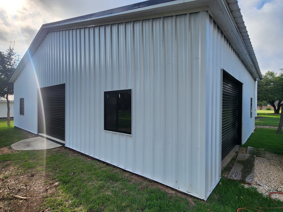 102 County Road 180 Leander, TX 78641 - Photo 16 of 25 A versatile metal structure offers practical utility with multiple access points for vehicles and equipment.