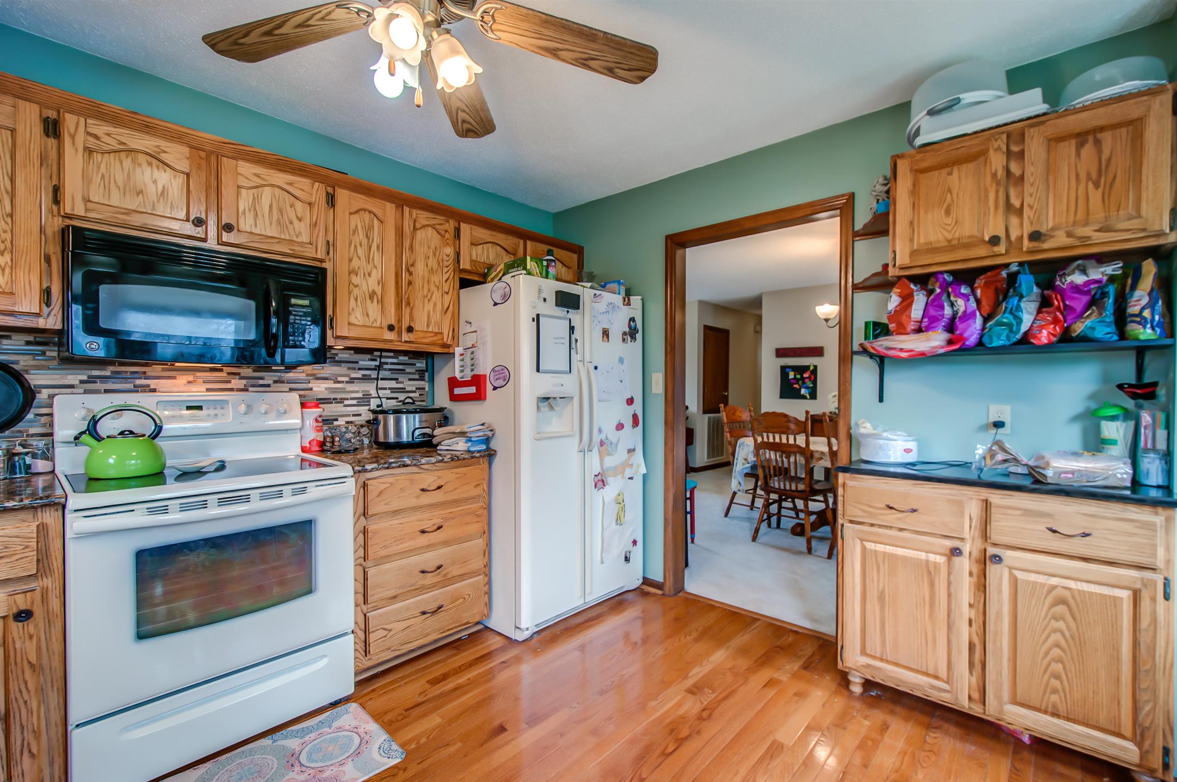 2142 Clara Mathis Road Spring Hill, TN 37174 - Photo 9 of 20 a kitchen with white cabinets stainless steel appliances and wooden floor