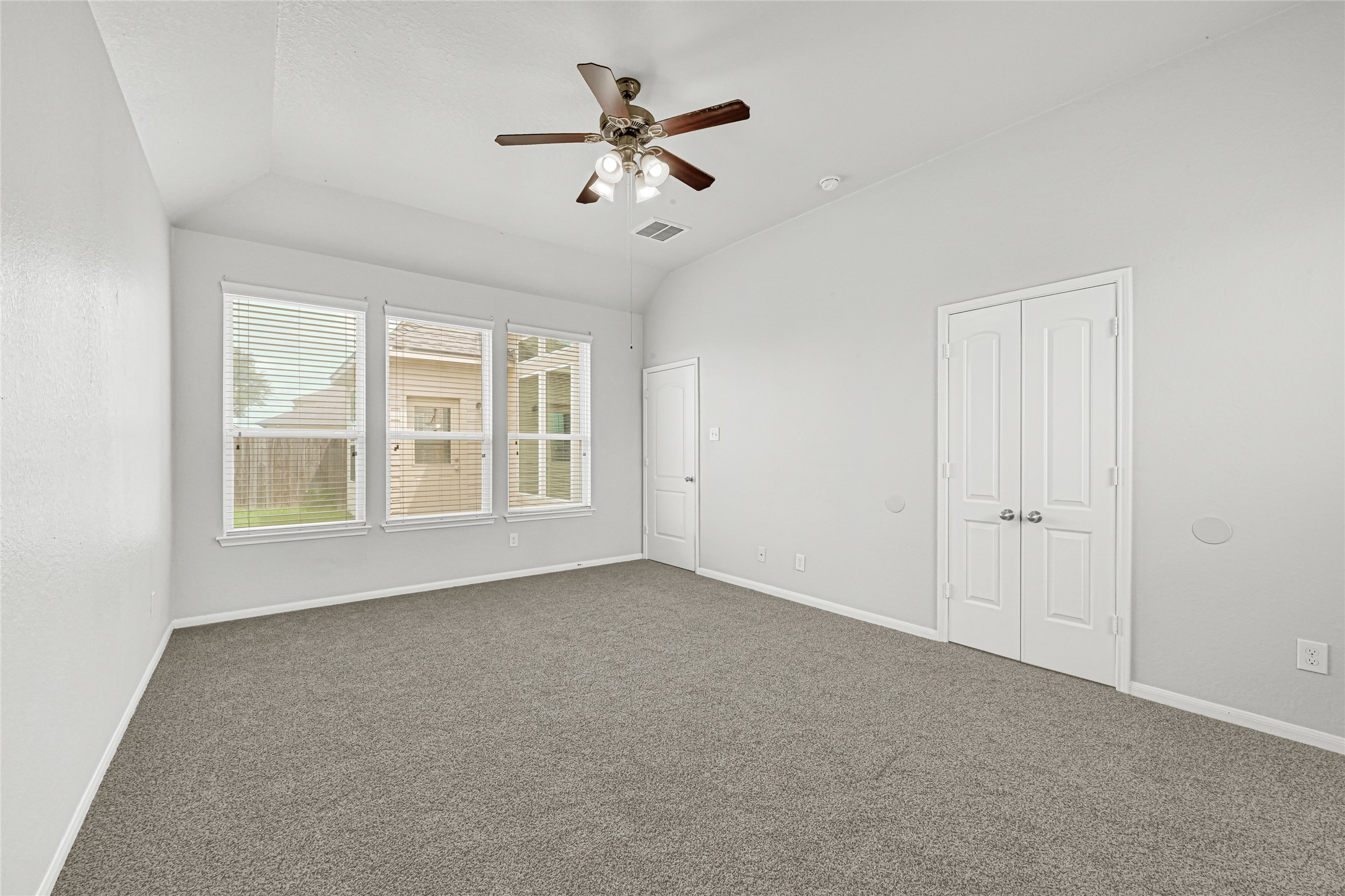 4702 Sedgewood Drive Rosenberg, TX 77471 - Photo 18 of 24 Large Primary bedroom with window looking onto backyard patio and double doors to enter the primary bathroom suite.