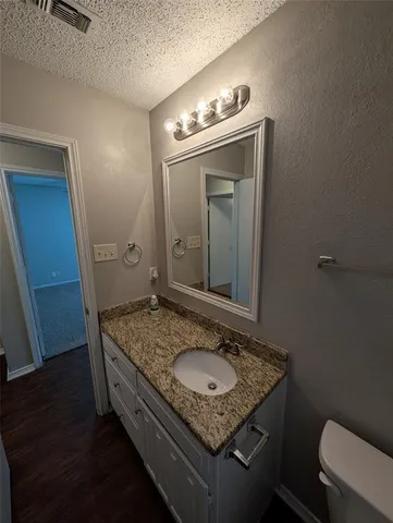 a bathroom with a granite countertop sink and a mirror