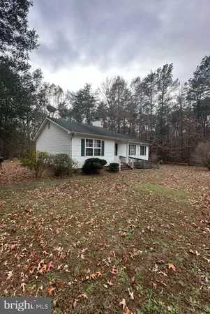 a front view of a house with a garden and yard