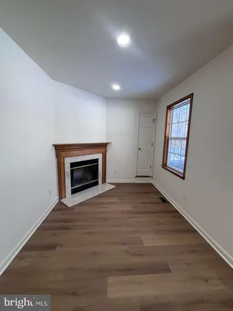 a view of an empty room with a fireplace and a window