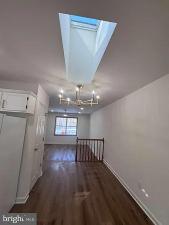 en empty room with wooden floor and window