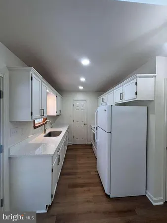 a kitchen with refrigerator and cabinets
