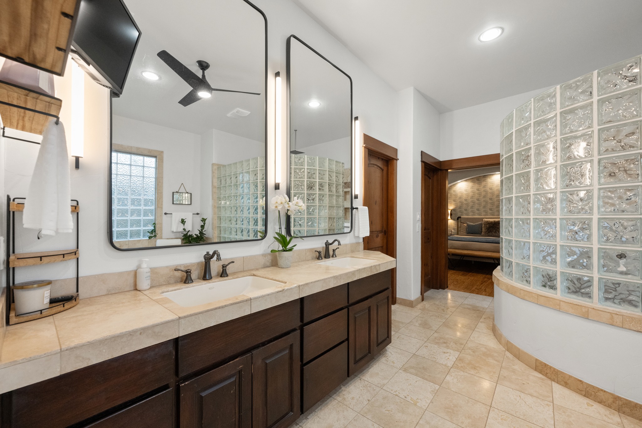 407 Hurst Creek Road Lakeway, TX 78734 - Photo 16 of 40 The primary bathroom has dual vanities, an indoor/outdoor shower behind the rounded glass wall, and a corner garden bathtub.