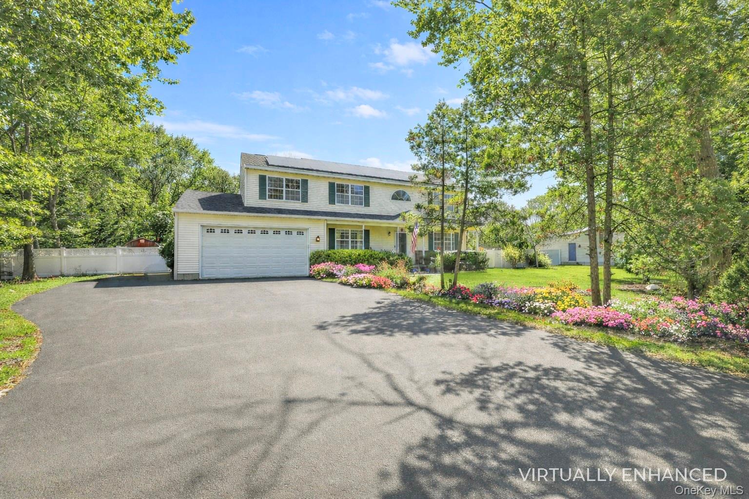 17 Jennifers Path Westhampton Beach, NY 11978 - Photo 6 of 41 a front view of a house with a yard and a garage