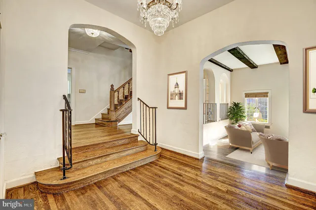 a view of a livingroom with wooden floor and a chandelier